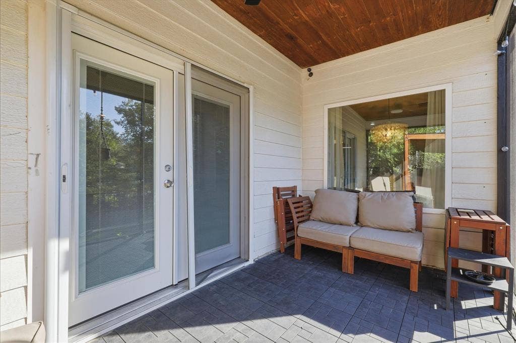 709 Woodbine Avenue, Dallas, TX 75203 Covered outdoor patio with a wood-finish ceiling, white horizontal siding, and a large window
