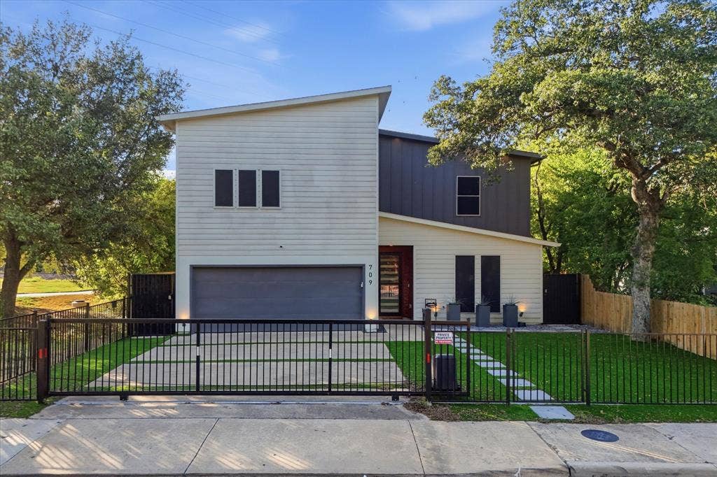 709 Woodbine Avenue, Dallas, TX 75203 Modern architectural design featuring multi-toned siding, integrated garage, and a gated entrance