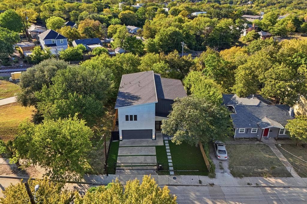 709 Woodbine Avenue, Dallas, TX 75203 Modern two-story residence featuring a dark gray roof, light-colored siding, and a two-car garage