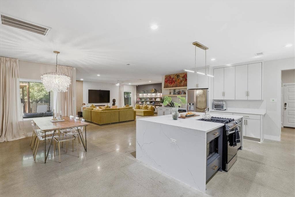 709 Woodbine Avenue, Dallas, TX 75203 Open-concept living space with polished concrete flooring, recessed lighting, and a modern kitchen island with an integrated cooktop and microwave