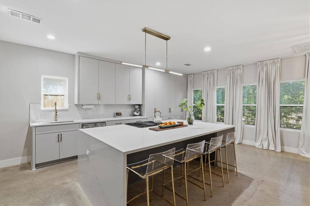 709 Woodbine Avenue, Dallas, TX 75203 Sleek kitchen featuring an oversized island with countertop seating, integrated gas cooktop, recessed lighting, and ample cabinetry