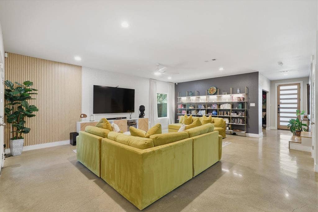 709 Woodbine Avenue, Dallas, TX 75203 Recessed lighting, light-toned flooring, built-in shelving, a wood-slat accent wall, and a slatted entry door