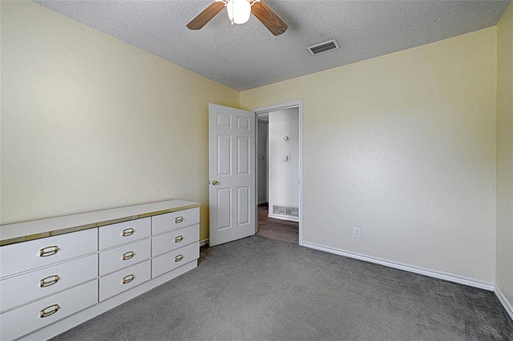 2909 Lee Park Drive, Irving, TX 75062 Room featuring neutral wall tones, gray carpeting, a multi-panel interior door, and a ceiling-mounted light fixture with a fan