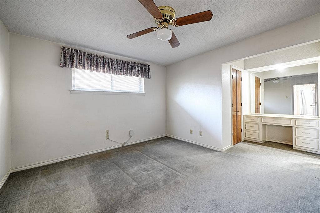 2909 Lee Park Drive, Irving, TX 75062 Room featuring a ceiling fan with wooden blades, wall-to-wall carpeting, and built-in cabinetry with an integrated vanity mirror
