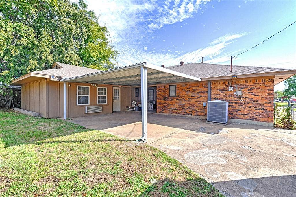 2909 Lee Park Drive, Irving, TX 75062 Exterior featuring a brick and composite siding facade, a covered carport with a metal roof, and concrete paving