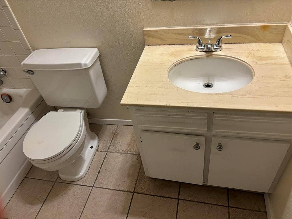 Bathroom with tile flooring, vanity, and toilet