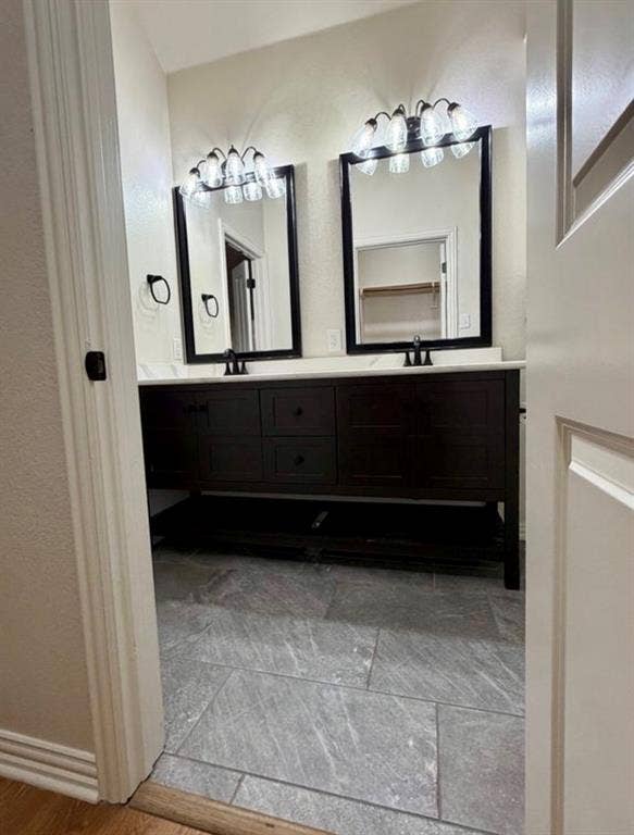 1001 Roberts Bend, Granbury, TX 76048 Dual vanity with dark wood cabinetry, white countertops, black-framed mirrors, and matching black fixtures