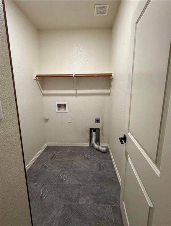 1001 Roberts Bend, Granbury, TX 76048 Laundry area featuring tiled flooring, a built-in wood-finish shelf, and a panel-style door with matte black hardware