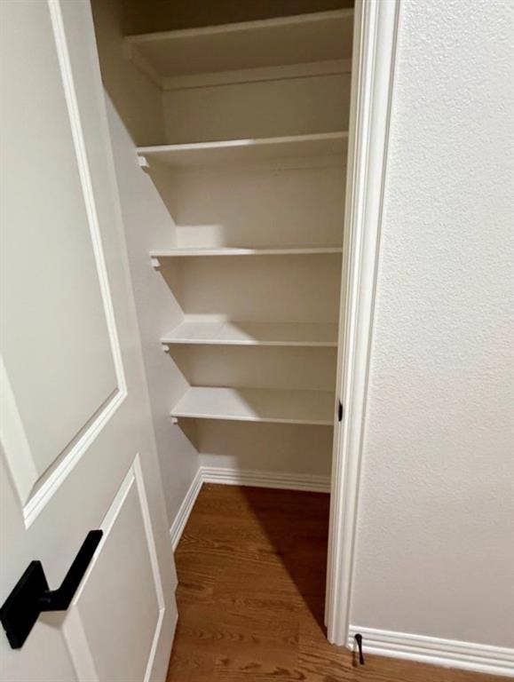1001 Roberts Bend, Granbury, TX 76048 Built-in shelving unit with multiple shelves, wood-finish flooring, and crisp white trim