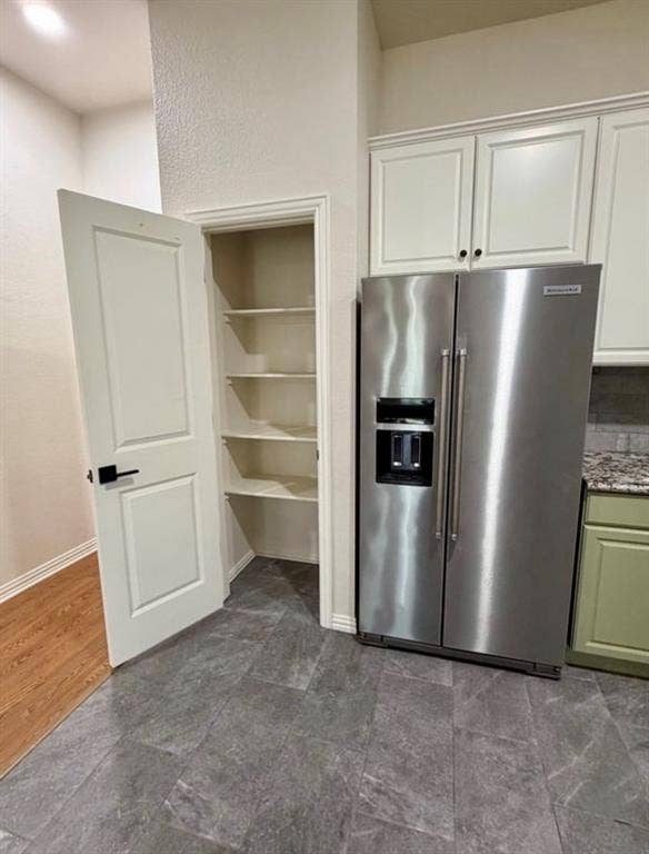 1001 Roberts Bend, Granbury, TX 76048 Stainless steel refrigerator, white upper cabinetry, green lower cabinetry, granite-finish countertop, and gray tile flooring