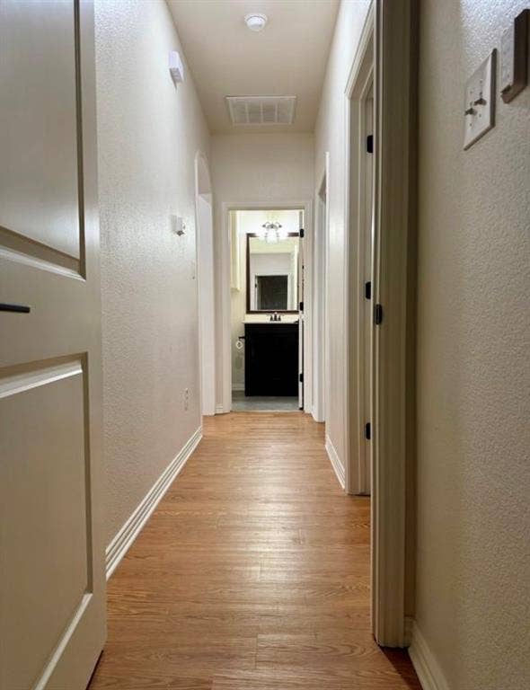 1001 Roberts Bend, Granbury, TX 76048 Wood-finish flooring extending through a neutral-toned hallway with an arched doorway