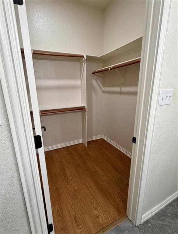 1001 Roberts Bend, Granbury, TX 76048 Walk-in closet featuring wood-finish flooring, multiple shelving units, and clothing rods