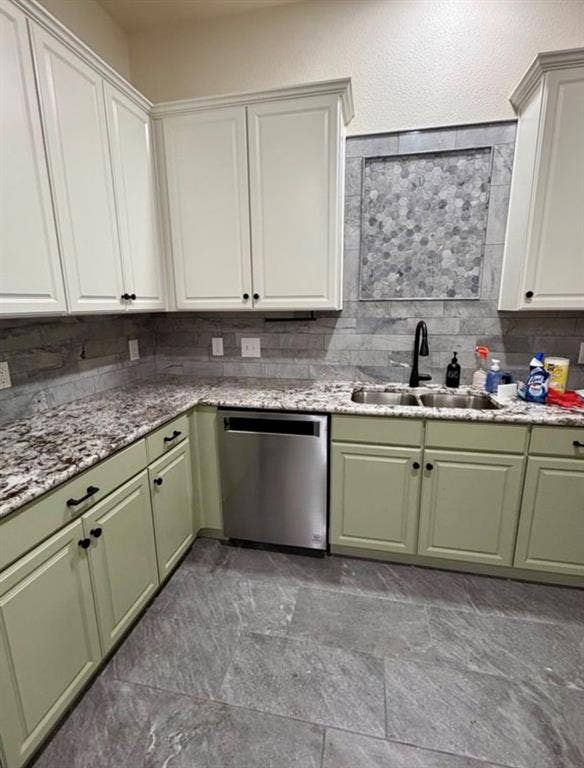 1001 Roberts Bend, Granbury, TX 76048 White shaker upper cabinetry, sage lower cabinetry, granite countertops, tile backsplash with decorative mosaic inlay, and stainless steel dishwasher