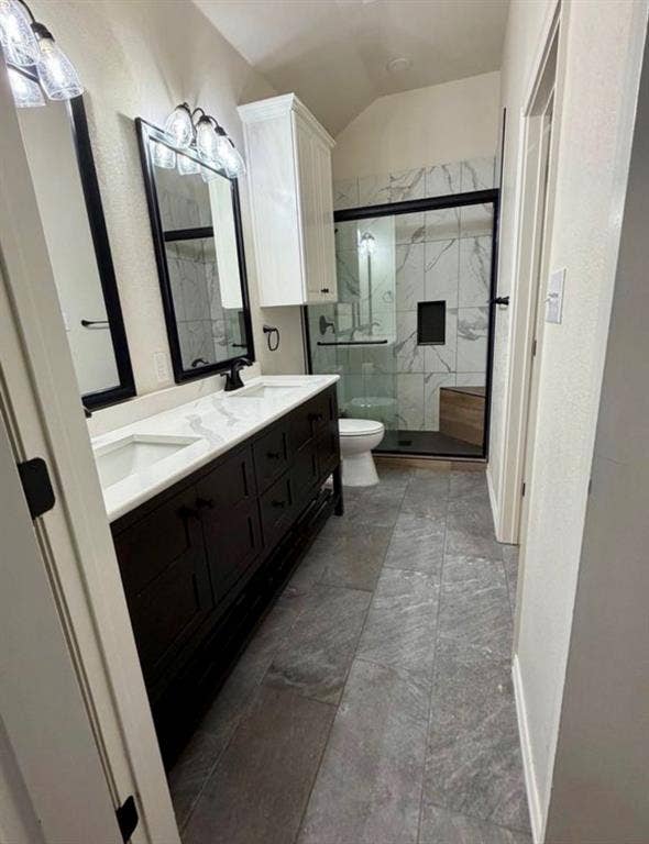 1001 Roberts Bend, Granbury, TX 76048 Primary bathroom featuring dual vanities with white quartz countertops, black cabinetry with integrated hardware, framed mirrors with black trim, and ceramic tile flooring