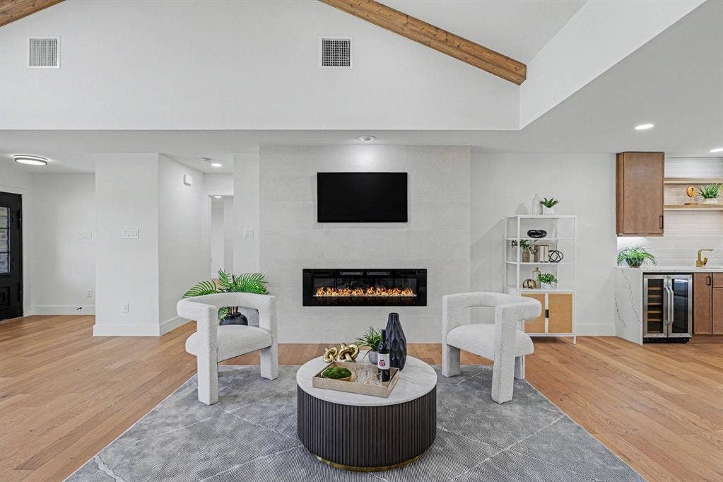 4004 Cedar Bayou Drive, Dallas, TX 75244 Hardwood flooring, vaulted ceiling with exposed wood beams, wall-mounted electric fireplace, and a built-in beverage cooler