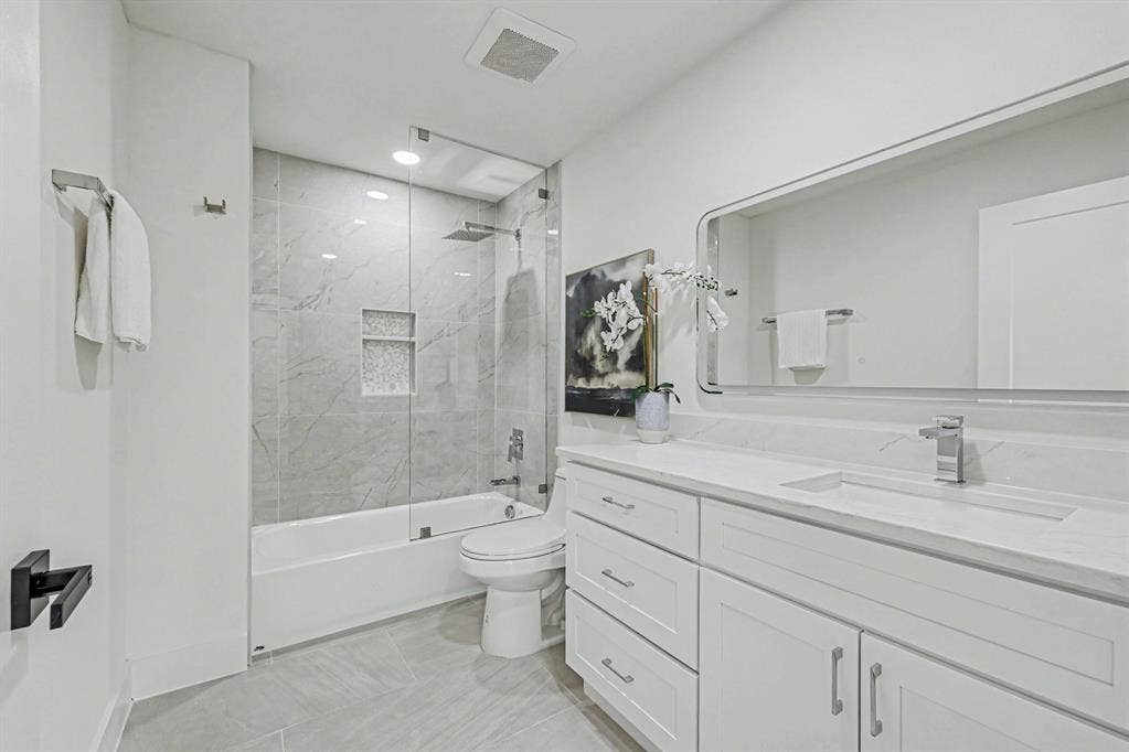 4004 Cedar Bayou Drive, Dallas, TX 75244 Tiled shower with glass enclosure and recessed niches, dual vanity with undermount sinks, and a large mirrored cabinet