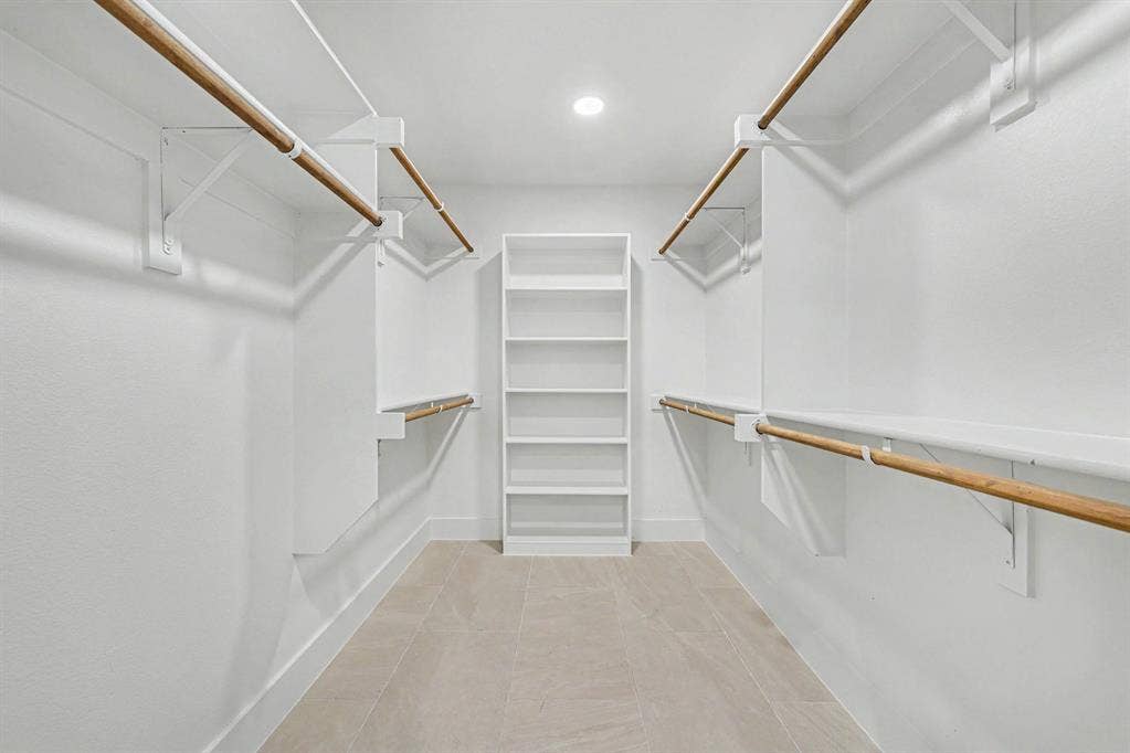 4004 Cedar Bayou Drive, Dallas, TX 75244 Integrated shelving system with multiple hanging rods, built-in open shelving, recessed ceiling light, and light-toned tile flooring