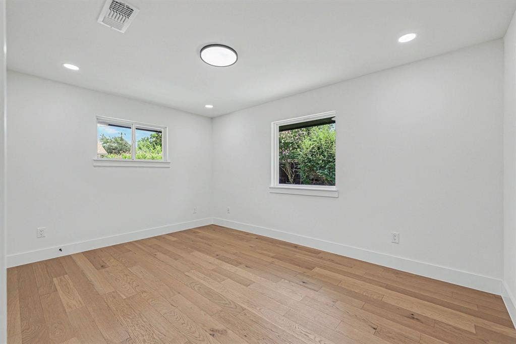 4004 Cedar Bayou Drive, Dallas, TX 75244 Wood-finish flooring, recessed lighting, and two windows with white trim