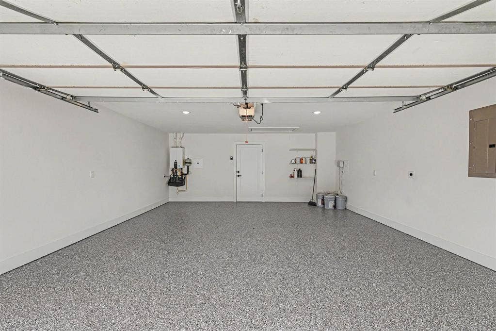 4004 Cedar Bayou Drive, Dallas, TX 75244 Spacious garage with an epoxy floor finish, recessed ceiling lighting, and a tankless water heater