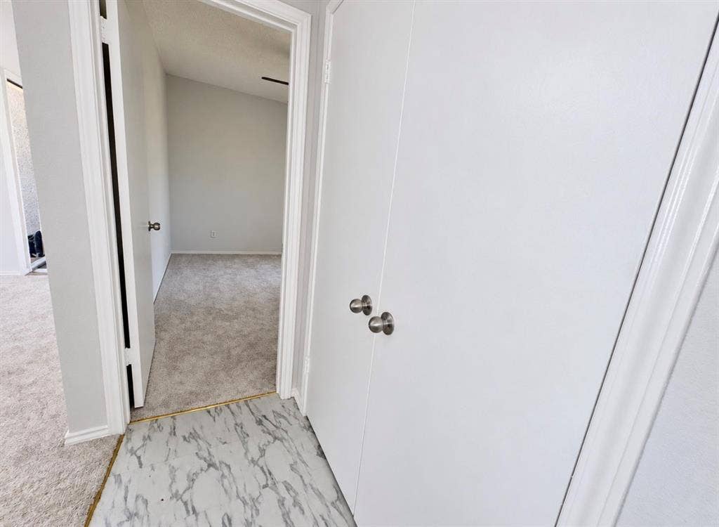 7126 Holly Hill Drive, #108, Dallas, TX 75231 Interior features include clean white doors with brushed nickel hardware, light grey textured carpeting, and white trim