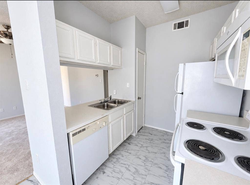 7126 Holly Hill Drive, #108, Dallas, TX 75231 Kitchen featuring white cabinetry, dual basin stainless steel sink, white dishwasher, and white electric range