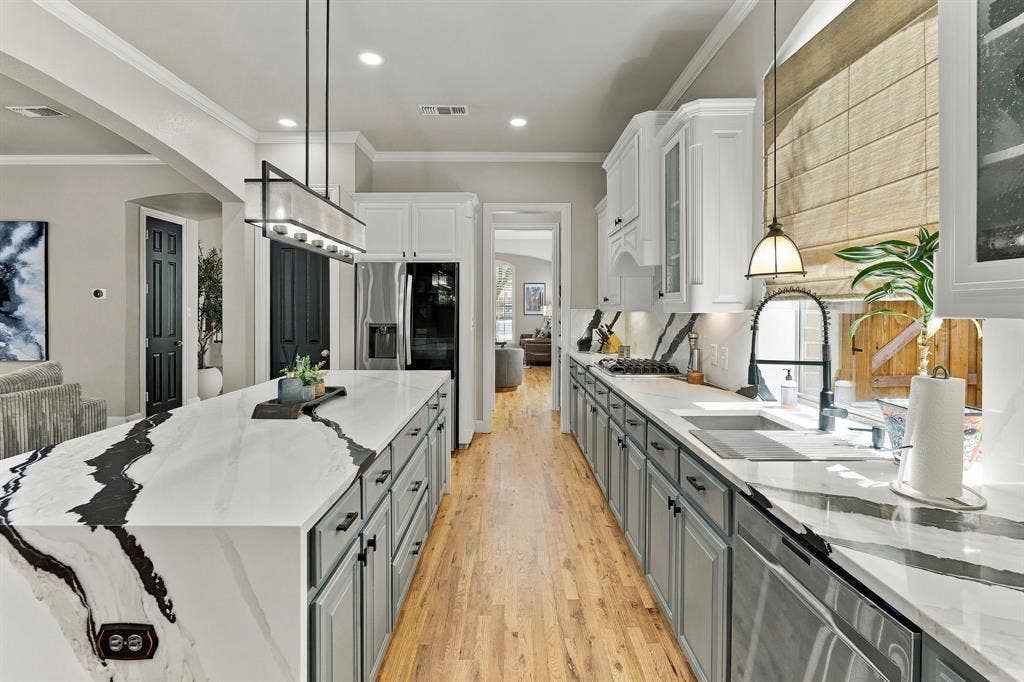 Kitchen Cooking Area | Gas cooktop, double ovens, generous counter space and abundant cabinetry complement the waterfall granite island.