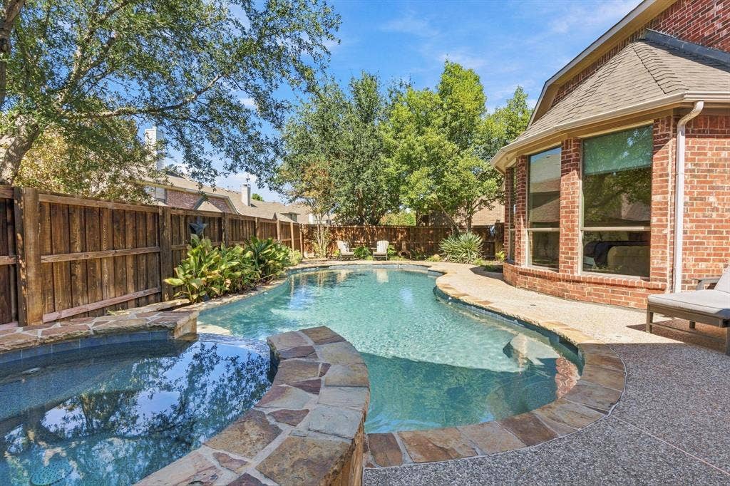 Backyard Pool and Spa | Heated gunite pool and spa with surrounding decking, mature landscaping and a fenced backyard.