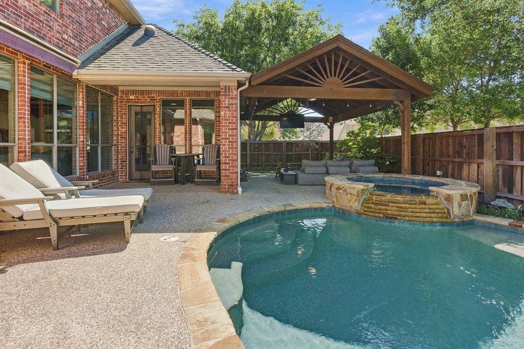 Pool, Spa and Covered Patio | Curved pool edges and the raised spa complement the adjacent covered outdoor living space.