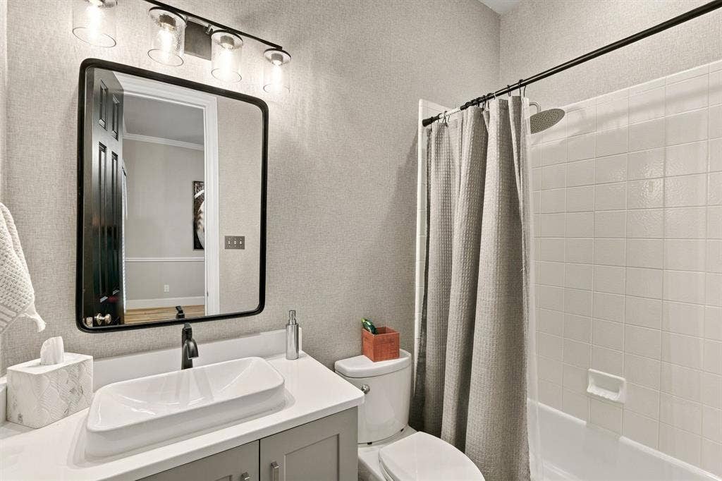 Main-Level Full Bathroom | Full bath with a vanity and tub-shower combination serves the downstairs secondary bedroom and nearby living areas.