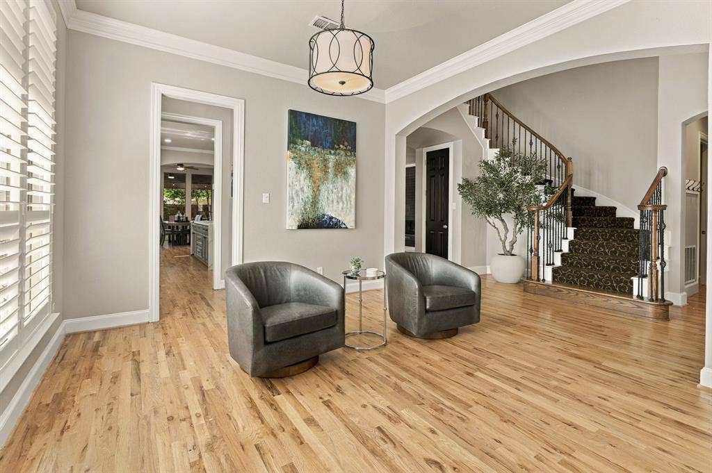 Formal Dining Room, Alternate View | Currently furnished as a sitting room, this flexible space features crown molding, wood floors and an arched connection to the formal living room.