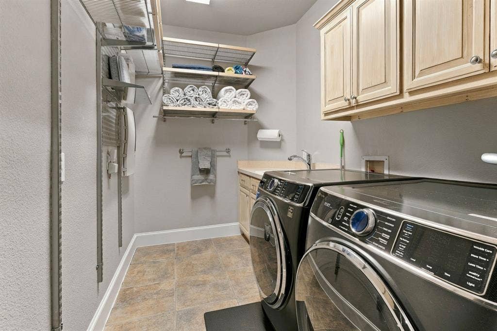 Laundry Room | Dedicated utility space with upper cabinets, hanging space and side-by-side laundry connections.
