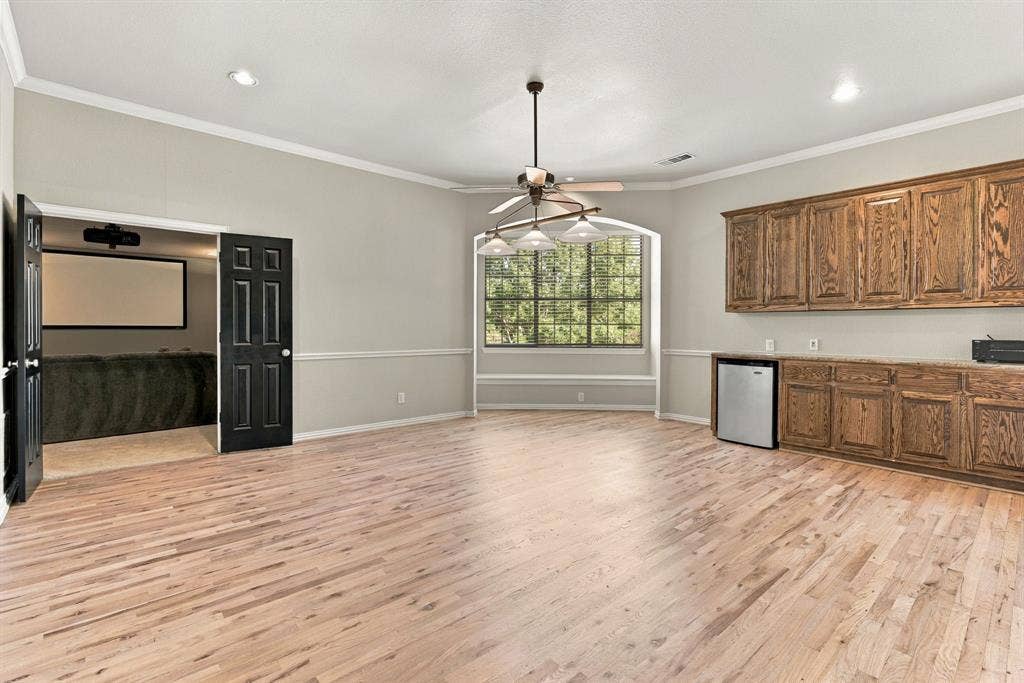 Upstairs Game Room | Large recreation space with built-in cabinetry, a ceiling fan and a window, offering room for games, hobbies or a second gathering area.