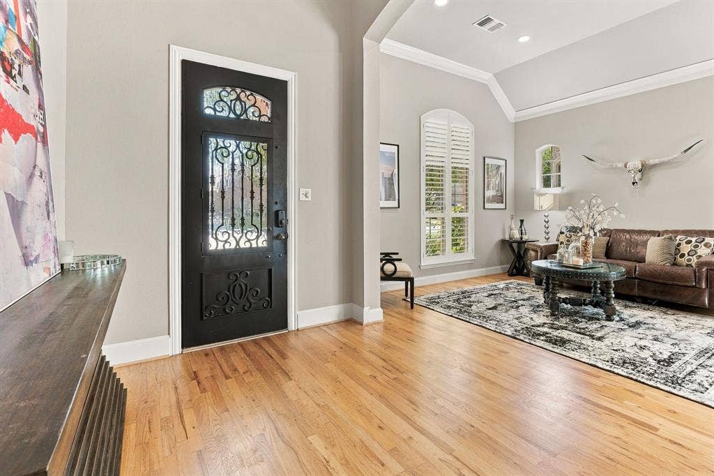 Entrance Foyer | Wood flooring, a decorative glass front door and open sightlines to the formal living room create a welcoming main-level entry.