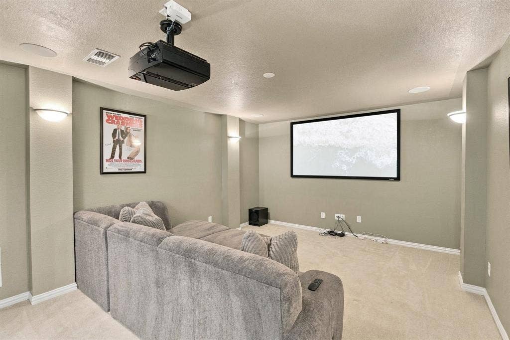 Dedicated Media Room | Upstairs media space with a projection screen, ceiling-mounted projector and room for comfortable movie-night seating.