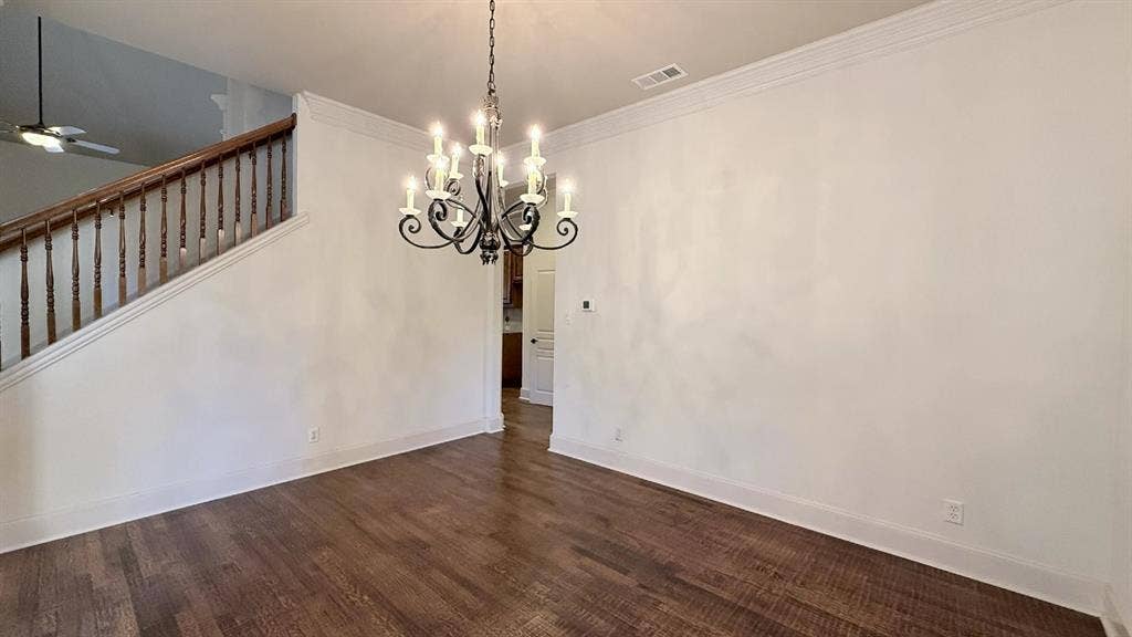 5700 Travis Drive, Frisco, TX 75034 Dark wood-finish flooring, staircase with wood handrail, classic chandelier, and white crown molding