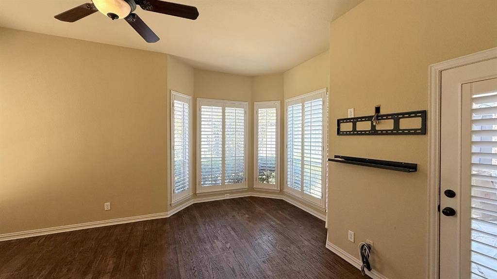 5700 Travis Drive, Frisco, TX 75034 Bay window with plantation shutters, wood-finish flooring, ceiling fan with integrated lighting, and a rear door with integrated blinds