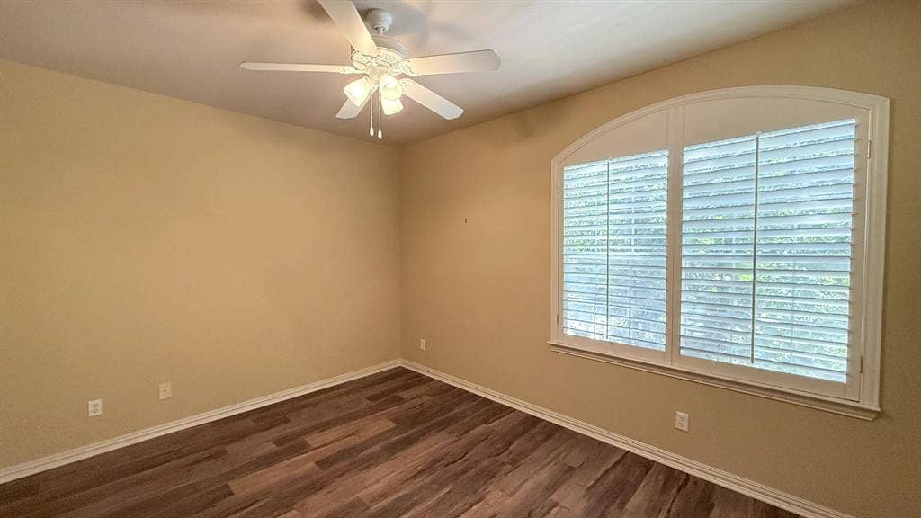 5700 Travis Drive, Frisco, TX 75034 Wood-finish flooring, overhead ceiling fan with light fixture, and arched window with plantation shutters