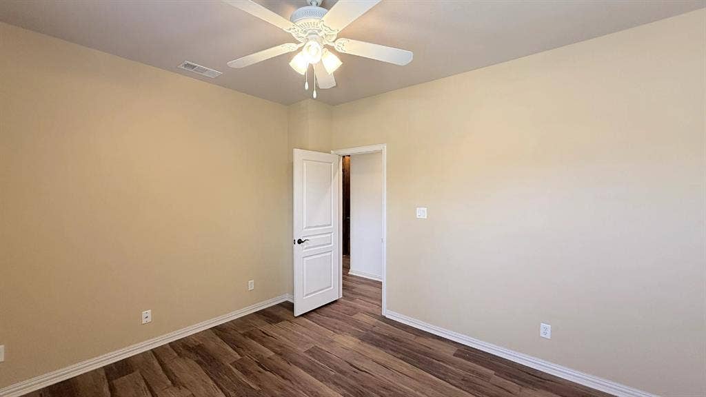 5700 Travis Drive, Frisco, TX 75034 Wood-finish flooring, light neutral wall tones, white trim, and a ceiling fan with integrated lighting