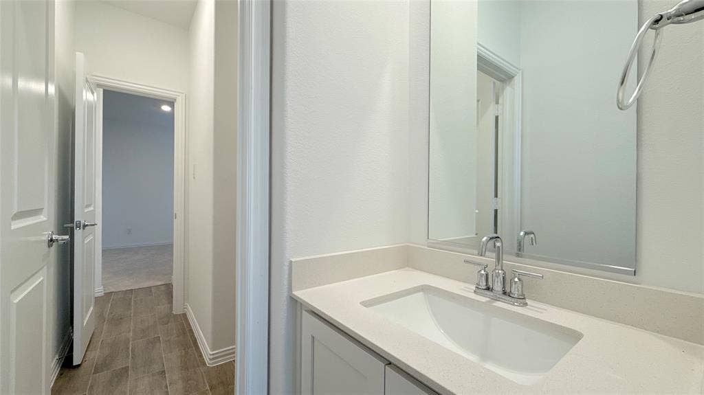Vanity with an integrated rectangular sink, chrome-finish faucet, and a large mirror