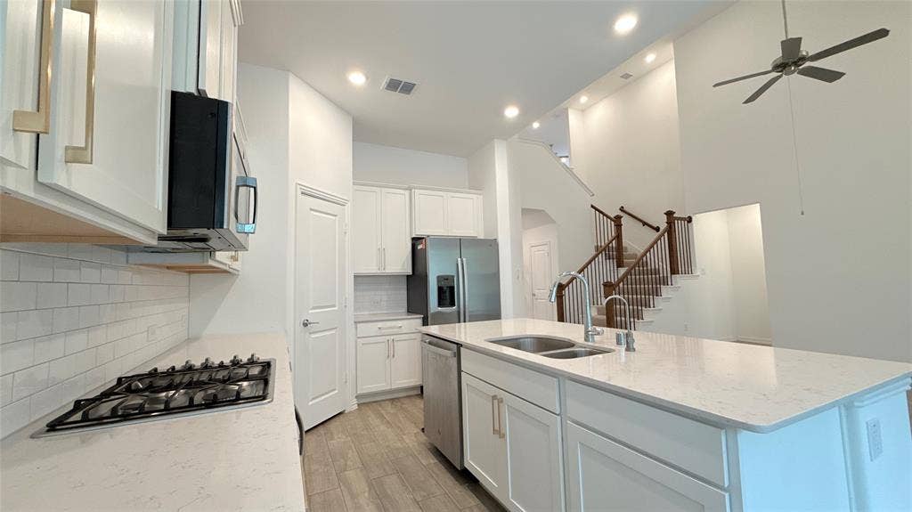 Gourmet kitchen featuring a gas cooktop, white subway tile backsplash, and stainless steel appliances