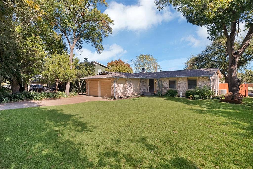 1400 Lorrie Drive, Richardson, TX 75080 View of front of home with concrete driveway, a front lawn, brick siding, and an attached garage