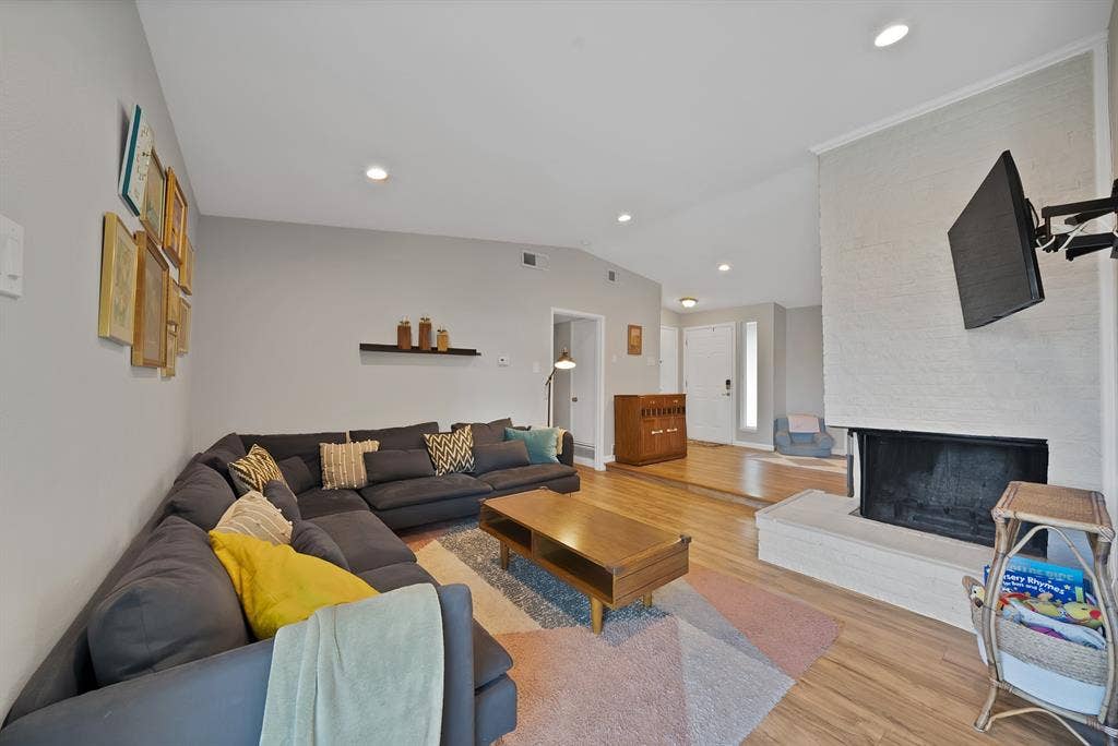 1400 Lorrie Drive, Richardson, TX 75080 Living area featuring vaulted ceiling, wood finished floors, a multi sided fireplace, and recessed lighting