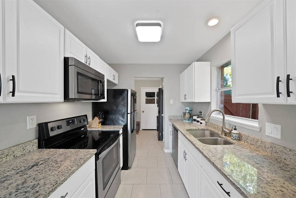 1400 Lorrie Drive, Richardson, TX 75080 Kitchen featuring stainless steel appliances, light stone countertops, white cabinetry, light tile patterned floors, and recessed lighting
