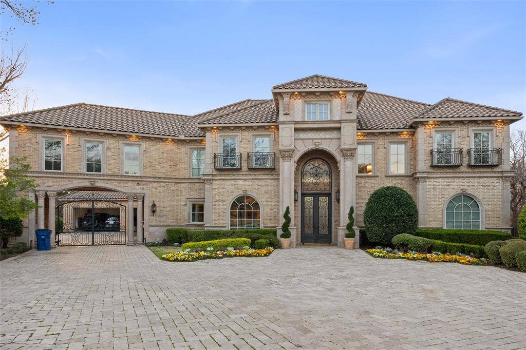 6300 Caroline Drive, Frisco, TX 75034 Mediterranean-style exterior featuring a tile roof, brick facade, arched entry, decorative iron double doors, and a paver driveway