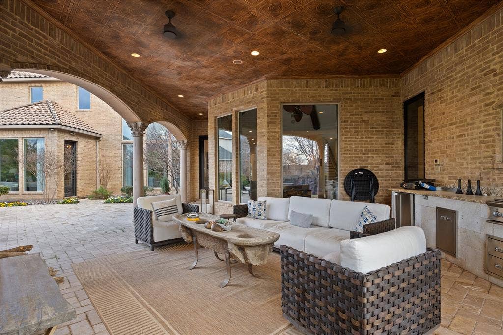 6300 Caroline Drive, Frisco, TX 75034 Expansive covered patio featuring a textured ceiling, recessed lighting, and a built-in outdoor kitchen with integrated appliances