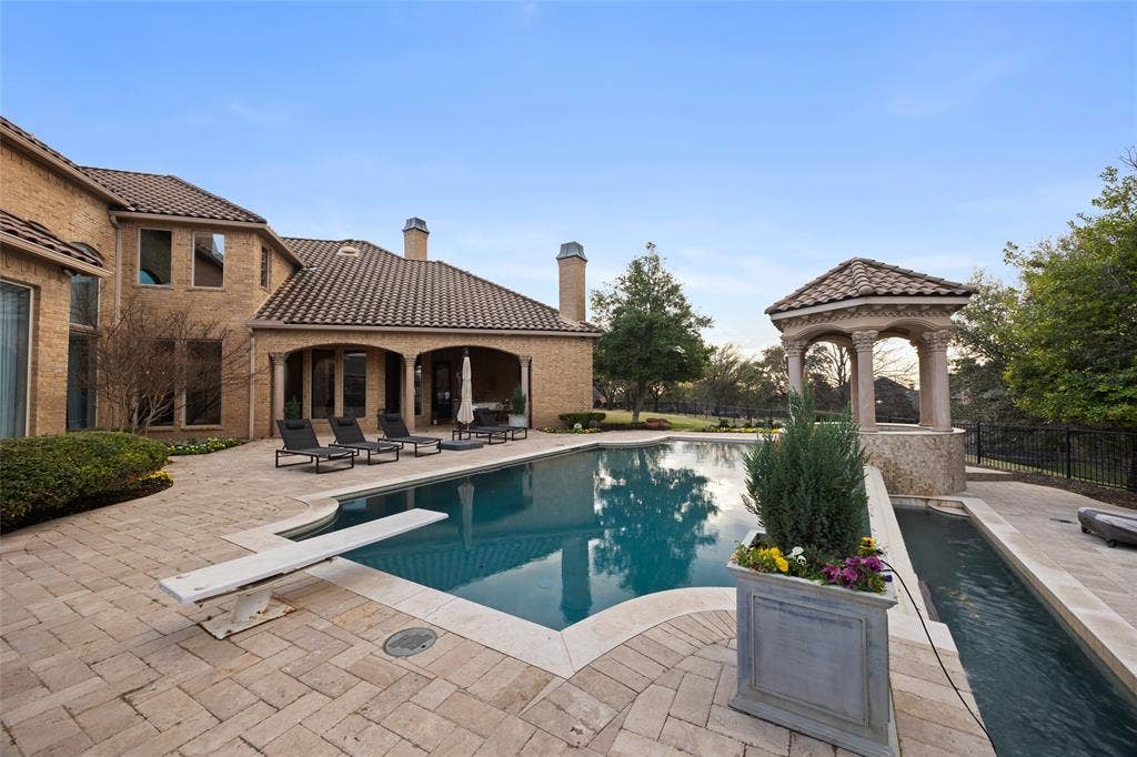 6300 Caroline Drive, Frisco, TX 75034 Expansive outdoor living area featuring a swimming pool with a diving board, surrounding paver patio, covered porch, and a stone gazebo