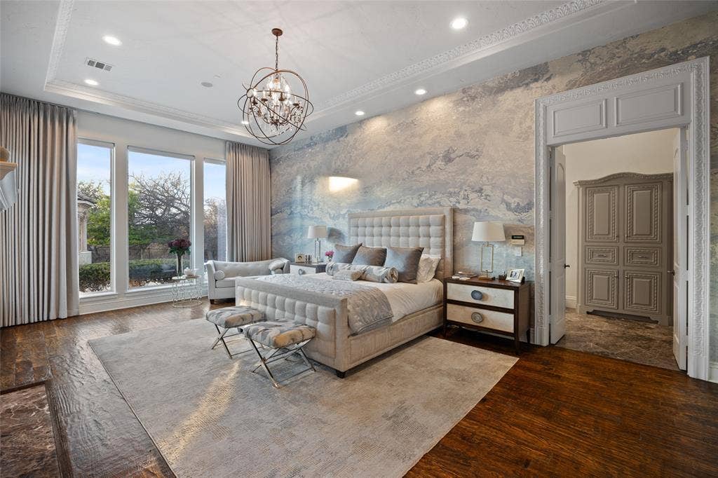 6300 Caroline Drive, Frisco, TX 75034 Hardwood flooring, tray ceiling with recessed lighting, detailed crown molding, custom wall treatment, and an ornate chandelier