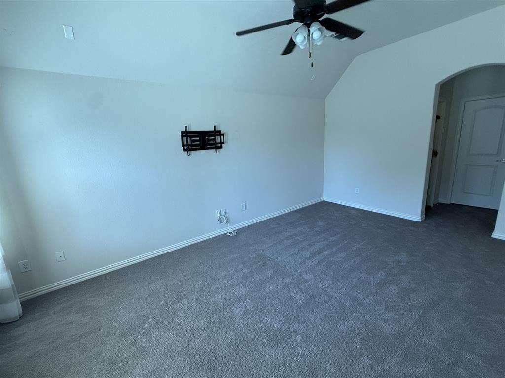 13721 Vera Cruz Road, Frisco, TX 75035 Carpeted room featuring a ceiling fan, sloped ceiling, and an arched doorway
