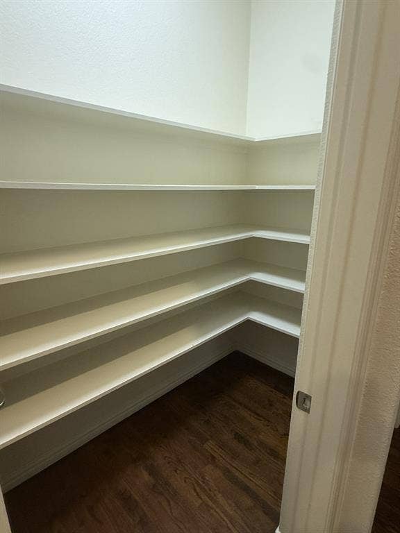 13721 Vera Cruz Road, Frisco, TX 75035 Corner pantry featuring multiple white shelves and wood-finish flooring