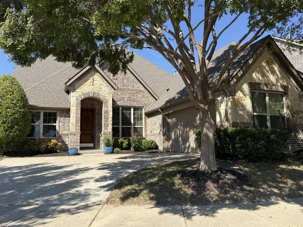 13721 Vera Cruz Road, Frisco, TX 75035 Brick exterior with stone accents, arched entryway, and an attached garage